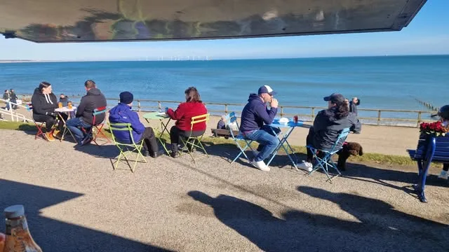 People eating UP•ROOTED food on the sand at Aberdeen beach
