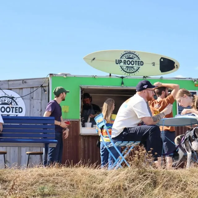 Customers at the green UP•ROOTED truck in the sun